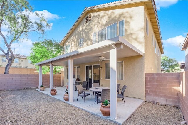 back of property with ceiling fan and a patio area