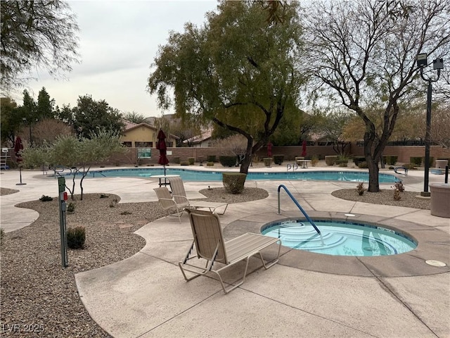 view of swimming pool featuring a patio area and a hot tub