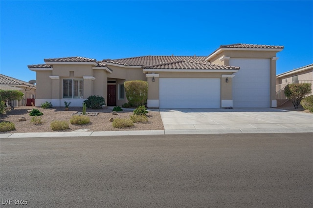 mediterranean / spanish home featuring a garage, driveway, a tiled roof, and stucco siding