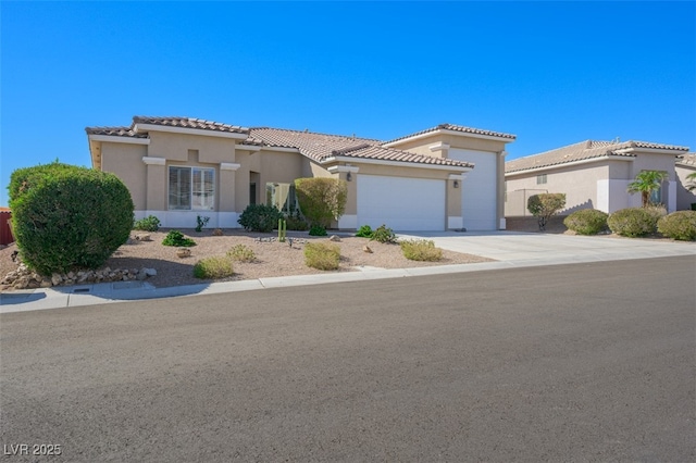 mediterranean / spanish-style house with concrete driveway, an attached garage, a tiled roof, and stucco siding