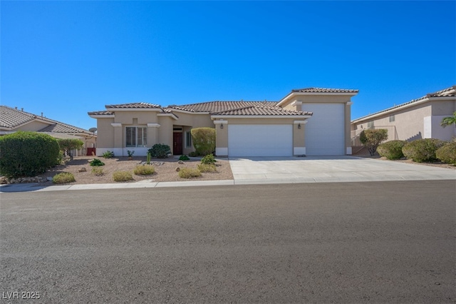 mediterranean / spanish-style house featuring concrete driveway, a tile roof, an attached garage, and stucco siding