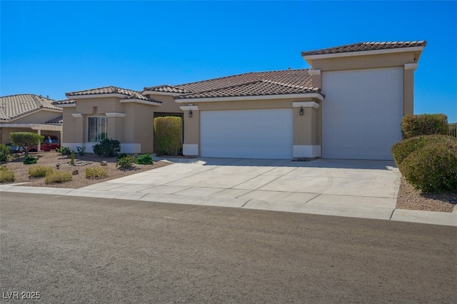 mediterranean / spanish-style home featuring a garage, driveway, a tiled roof, and stucco siding