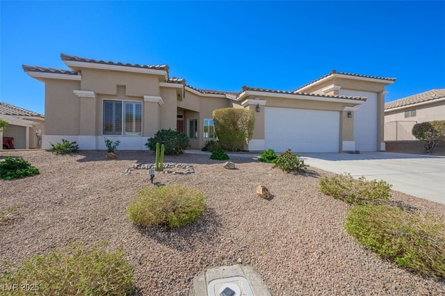 mediterranean / spanish-style home with a tile roof, driveway, an attached garage, and stucco siding