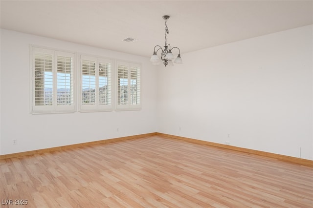 unfurnished room featuring light wood-type flooring, baseboards, and visible vents