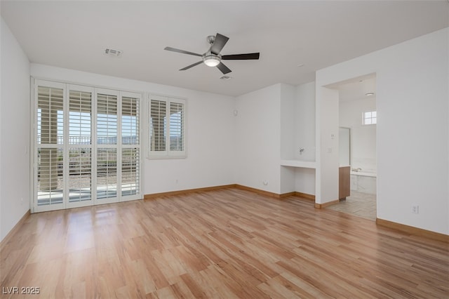 empty room featuring ceiling fan, baseboards, visible vents, and light wood-style floors