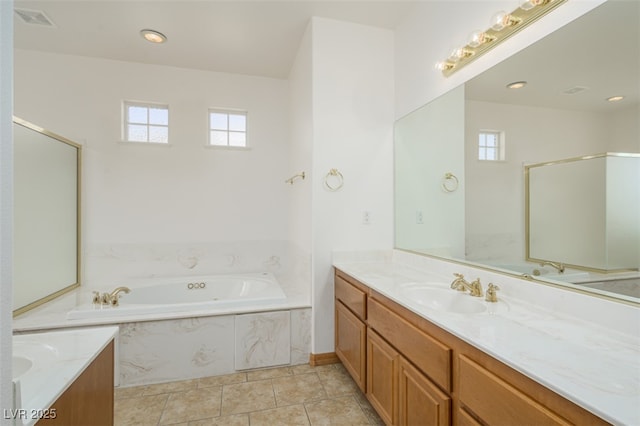 bathroom featuring a bath, a wealth of natural light, vanity, and visible vents