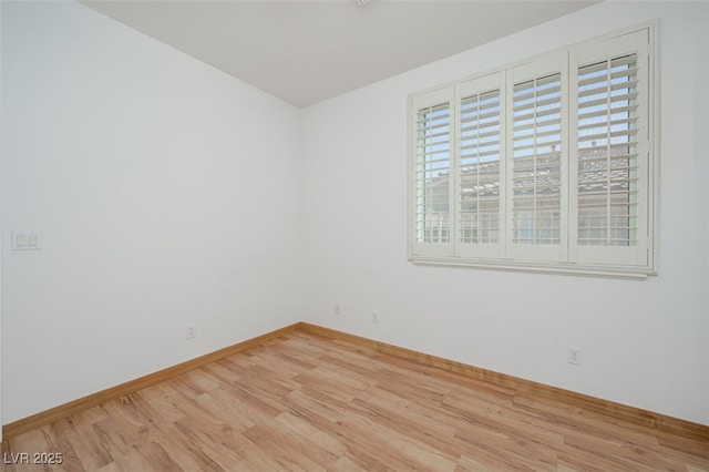 empty room with baseboards and wood finished floors