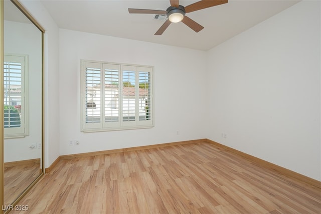 unfurnished room featuring ceiling fan, light wood-style flooring, and baseboards