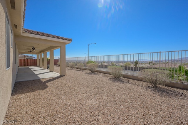 view of yard with ceiling fan, a patio area, and a fenced backyard