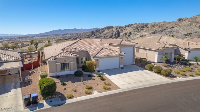 mediterranean / spanish-style house with a garage, driveway, a mountain view, and stucco siding