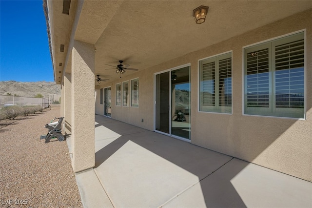 view of patio featuring ceiling fan and fence