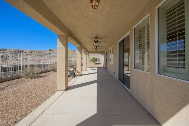 view of patio with ceiling fan and fence