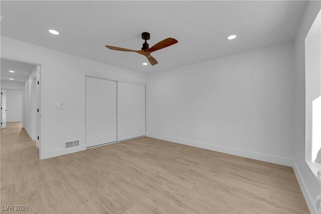 unfurnished bedroom featuring light hardwood / wood-style floors, ceiling fan, and a closet