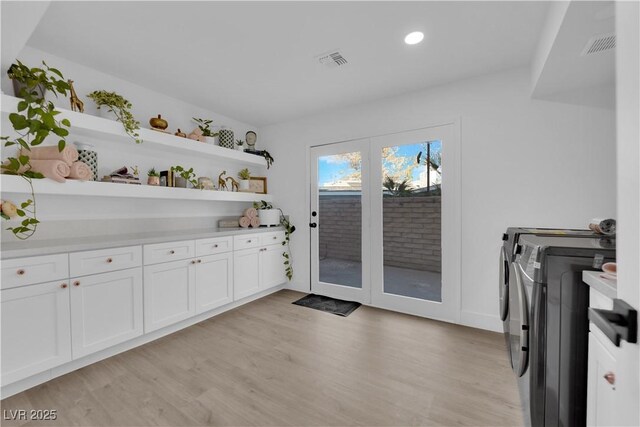 washroom with washing machine and clothes dryer and light wood-type flooring