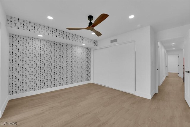 spare room with light wood-type flooring and ceiling fan