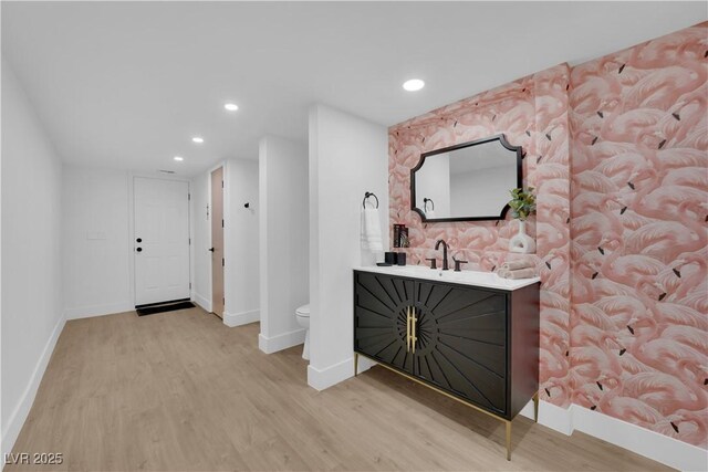 bar featuring sink and light hardwood / wood-style flooring