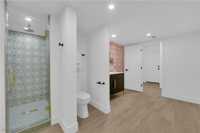 bathroom featuring hardwood / wood-style flooring, toilet, and an enclosed shower