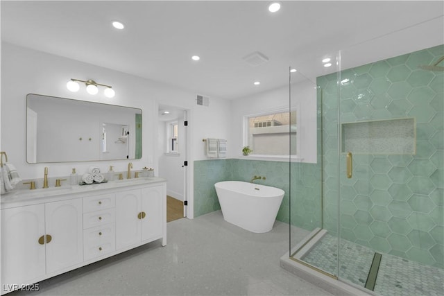 bathroom with vanity, separate shower and tub, and tile walls