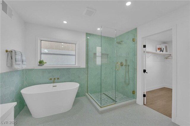 bathroom with separate shower and tub and tile walls