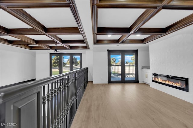 corridor with coffered ceiling, hardwood / wood-style floors, beam ceiling, and french doors