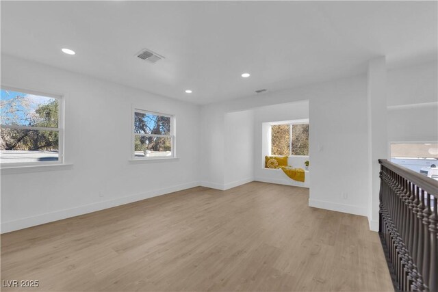 empty room featuring a wealth of natural light and light wood-type flooring