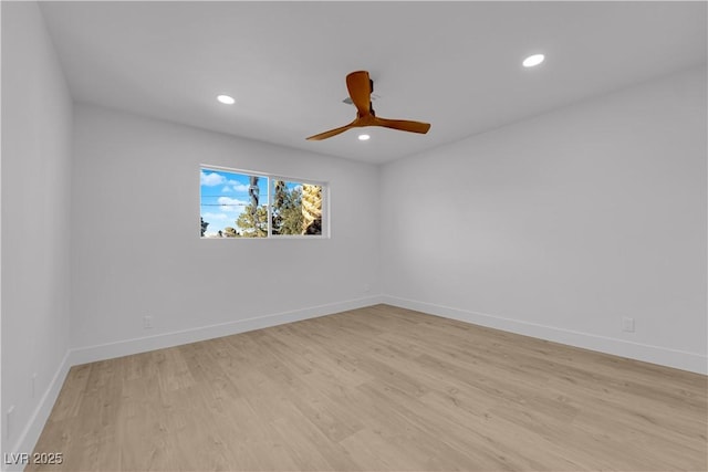 empty room with ceiling fan and light hardwood / wood-style flooring