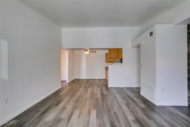 unfurnished living room with dark hardwood / wood-style flooring and ceiling fan