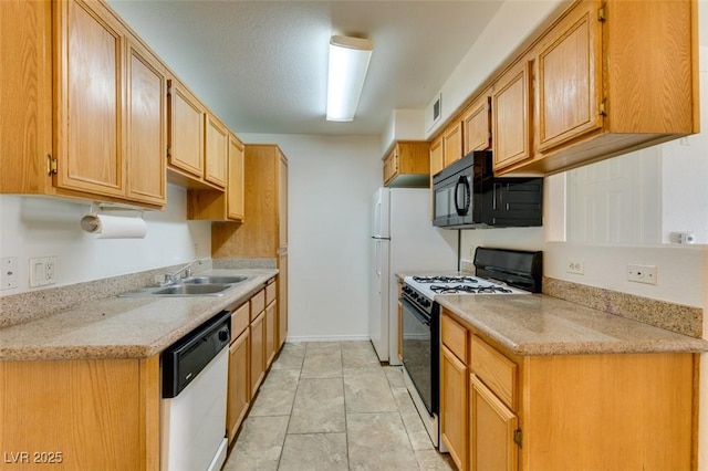 kitchen with light stone countertops, dishwasher, sink, gas range oven, and light tile patterned floors