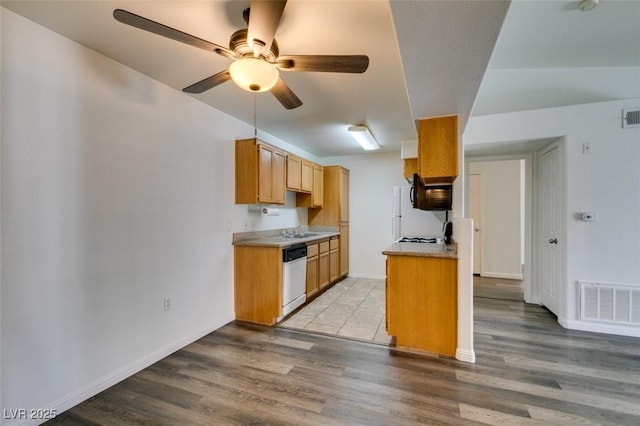 kitchen featuring dishwashing machine, sink, ceiling fan, and light hardwood / wood-style floors