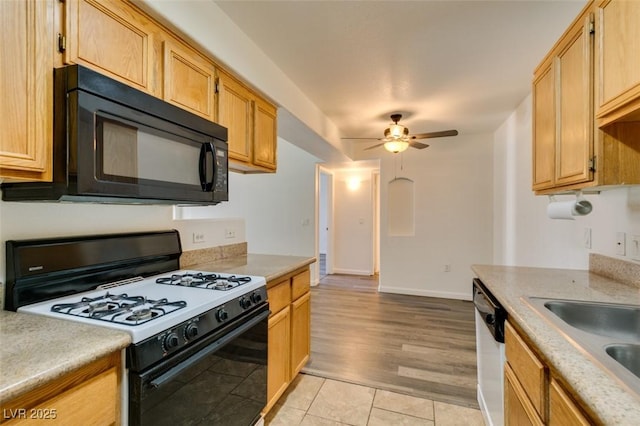 kitchen with ceiling fan, sink, range with gas cooktop, stainless steel dishwasher, and light brown cabinetry