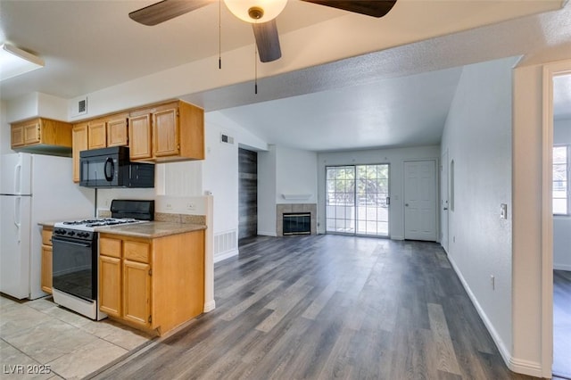 kitchen with ceiling fan, light brown cabinets, light wood-type flooring, and white appliances