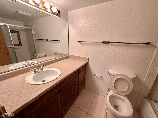 bathroom featuring vanity, tile patterned floors, toilet, a textured ceiling, and a shower with shower door