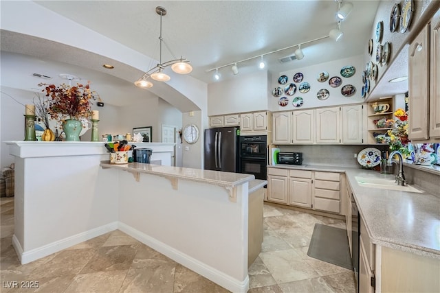 kitchen featuring sink, hanging light fixtures, black double oven, kitchen peninsula, and stainless steel refrigerator