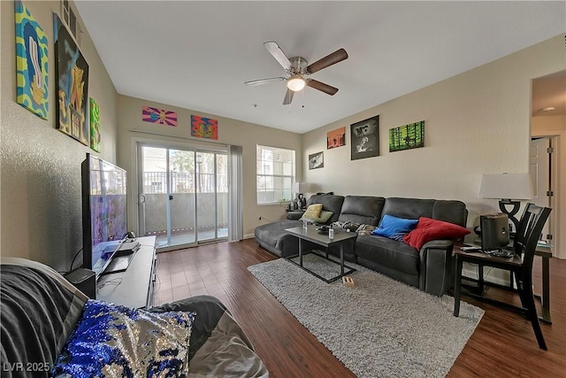 living room with ceiling fan and dark wood-type flooring