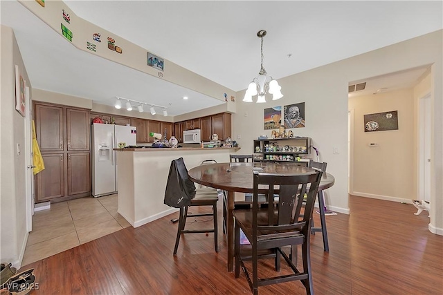 dining space featuring a chandelier and light wood-type flooring