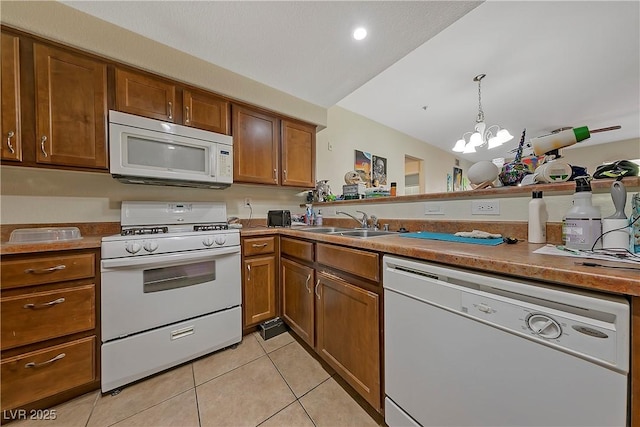 kitchen with sink, hanging light fixtures, an inviting chandelier, white appliances, and light tile patterned floors