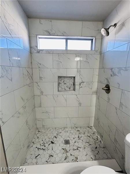 bathroom featuring toilet and tiled shower