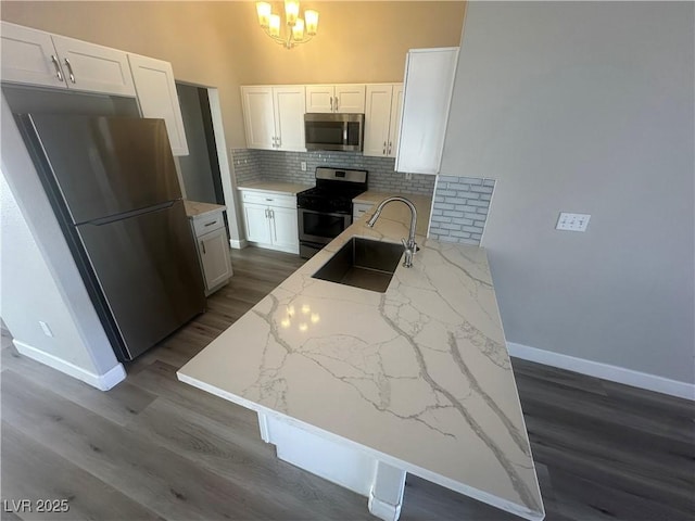 kitchen featuring light stone counters, white cabinetry, appliances with stainless steel finishes, and dark hardwood / wood-style flooring