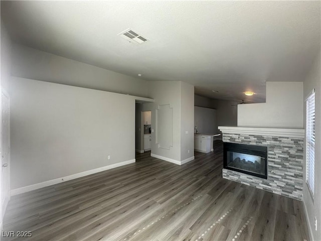 unfurnished living room featuring a fireplace and dark hardwood / wood-style floors