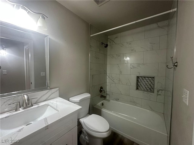 full bathroom with toilet, tiled shower / bath, and vanity