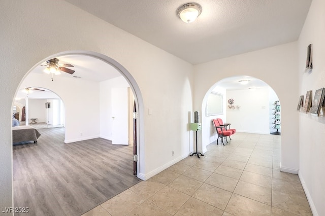 hallway featuring light tile patterned floors and a textured ceiling