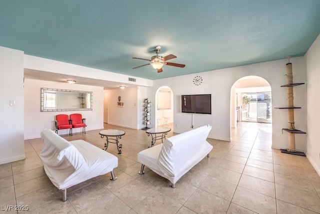 living room with light tile patterned floors, a wealth of natural light, and ceiling fan