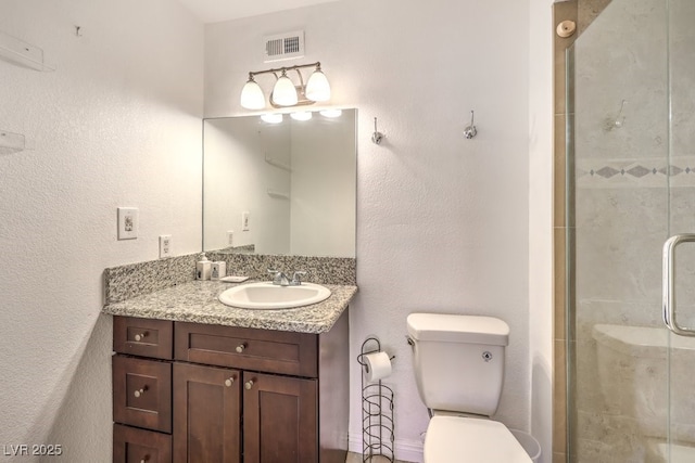 bathroom featuring vanity, toilet, and walk in shower