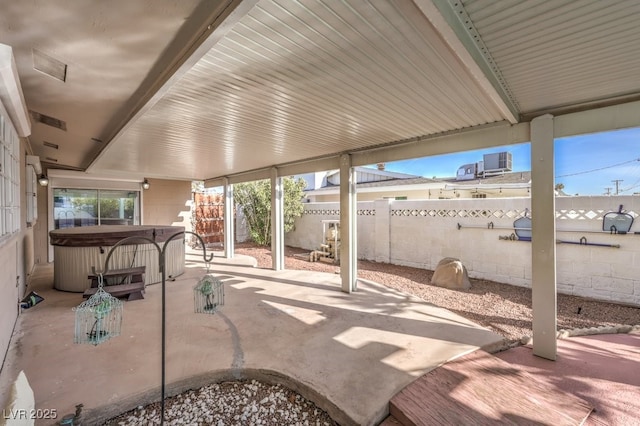 view of patio featuring cooling unit and a hot tub