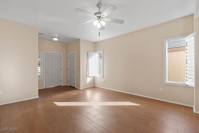 unfurnished room featuring ceiling fan, a wealth of natural light, and wood-type flooring