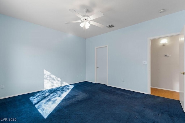 carpeted spare room featuring ceiling fan