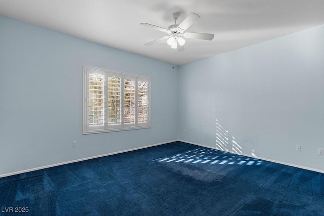 empty room with ceiling fan and dark colored carpet