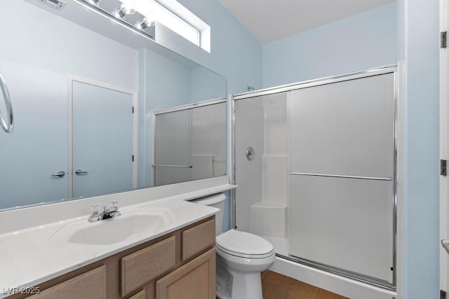 bathroom with hardwood / wood-style flooring, toilet, vanity, and walk in shower