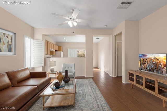 living room featuring dark wood-type flooring and ceiling fan