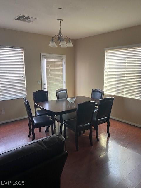 dining space featuring wood-type flooring and a chandelier